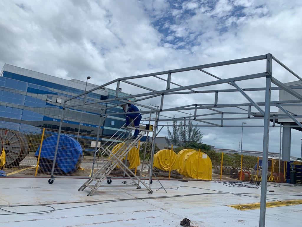 Equipe instalando estrutura metálica em campo